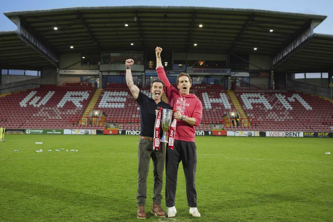 Wrexham co-owners Rob McElhenney, left, and Ryan Reynolds pose with trophy at the end of the English League One soccer match between Wrexham and Charlton Athletic at the Racecourse ground in Wrexham, Wales, Saturday, April 26, 2025. (AP Photo/Jon Super)